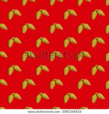 Seamless Christmas texture, golden pine cone on a red background. Sample.