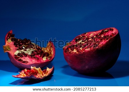 Peeled natural organic pomegranate on blue studio background