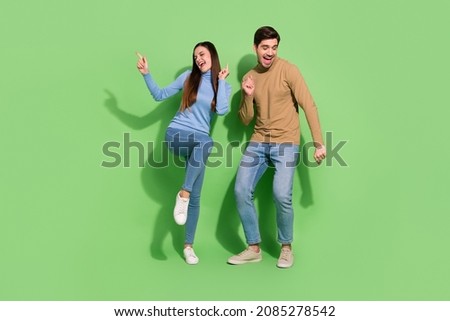 Photo of carefree positive couple enjoy festive disco atmosphere wear casual outfit isolated green color background