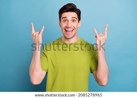 Portrait of attractive cheerful cool guy showing two double horn sign having fun isolated over bright blue color background
