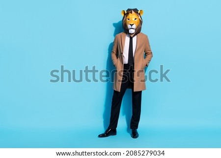 Photo of anonym guy hide face lion mask cool business shark employer put hands pockets isolated over blue color background