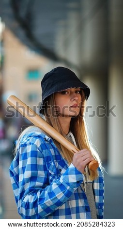 girl in a shirt waving a baseball bat