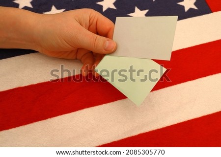 American flag, part of. With cards for your design, held in a hand. US-style. Made as a blanket. The stars and stripes. Concept of success in business, take a card. Copy space.