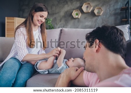 Portrait of attractive adorable cheerful life partners sitting on divan playing mum dad babysitting good morning at home indoors Royalty-Free Stock Photo #2085311119