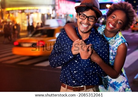 Couple smiling on city street at night