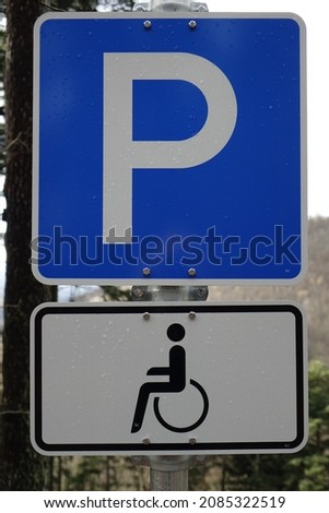 Blue, white and black traffic sign 'Disabled  handicapped parking only' with water drops  on the surface, Hermersbergerhof, Wilgartswiesen, Rhineland Palatinate, Germany
