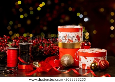 Christmas gift boxes, packing tape and balls on bokeh background, new year attributes. High quality photo