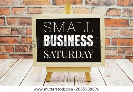 Small Business Saturday typography text on the blackboard set on wooden floor and brick background Royalty-Free Stock Photo #2085388696