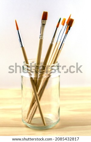 brushes for drawing of various diameters in a glass jar on a white background. High quality photo