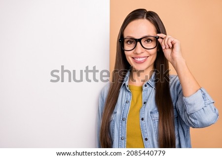 Photo of beautiful positive businesswoman wear spectacles advertisement placard isolated on beige color background