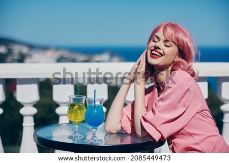 Young female drinking a cocktail on the terrace Happy female relaxing