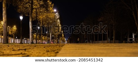 Night view of a walking path with a lights and a road on the side as a background