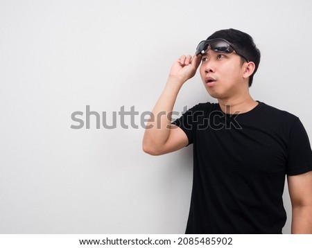 Asian man take off his sunglasses for looking at copy space feeling excited