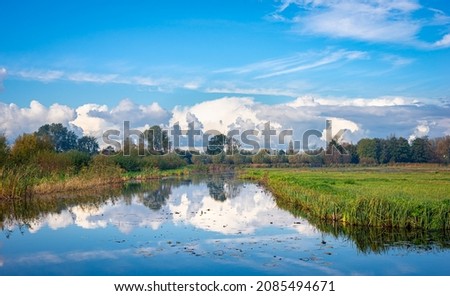 Scenic view of wetland recreational area 't Weegje near Gouda, the Netherlands. Beautiful reflections of clouds and the blue sky in the calm water.