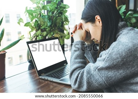 Exhausted caucasian student working on laptop, suffering from headache or migraine. Tired male employee and computer with blank screen. Mockup Royalty-Free Stock Photo #2085550066