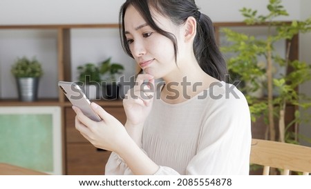A young woman using a smartphone at home