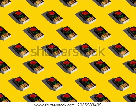 Black open boxes of matches on a yellow background. Pattern, composition, background