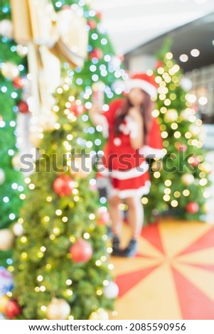 Blur Santa woman, woman in Santa Claus costume and Christmas tree in Merry Christmas xmas indoors