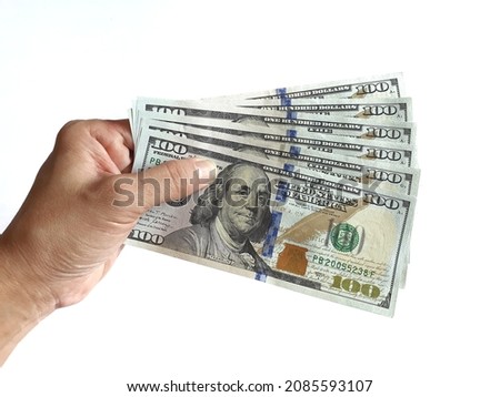 Human hand holding several 100 dollar banknotes on a white background.
