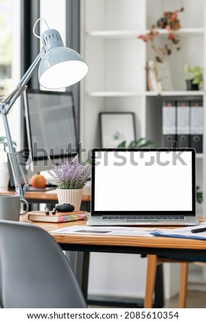 Mockup blank screen laptop computer on wooden table in modern room. Creative workspace with laptop. Blank screen laptop for product display. Vertical view. Royalty-Free Stock Photo #2085610354