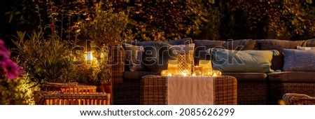Trendy furniture, lights, lanterns and candles in the garden at night Royalty-Free Stock Photo #2085626299