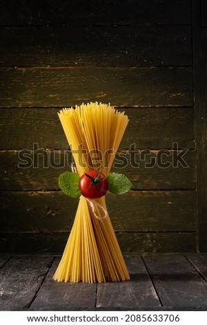 Spaghetti and cherry tomatoes. Not cooked spaghetti. Spaghetti standing upright. Royalty-Free Stock Photo #2085633706