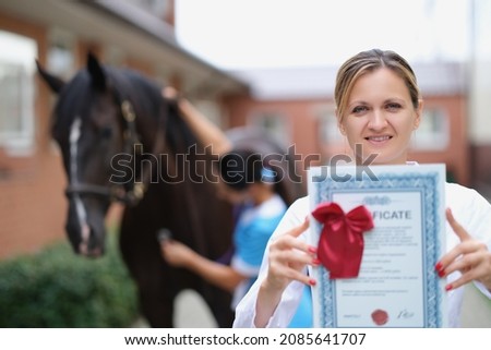Woman doctor shows horse veterinary certificate