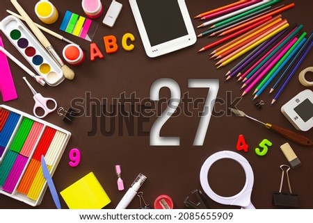 June 27th. Day 27 of month, Calendar date. School notebook and various stationery with calendar day. School and office supplies frame. Summer month, day of the year concept