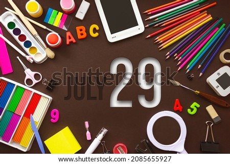July 29th. Day 29 of month, Calendar date. School notebook and various stationery with calendar day. School and office supplies frame. Summer month, day of the year concept