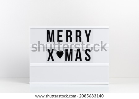 Lightbox with text MERRY XMAS on white table. Minimal Christmas or New Year concept.