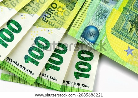 Macro photo of the European Union 100 EURO banknote, bills arranged in a fan, isolated on a white background, top view.