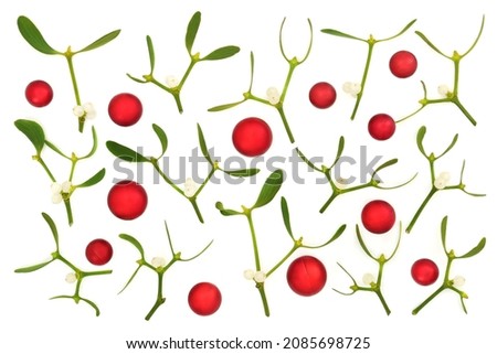 Christmas background with red ball baubles and mistletoe sprigs on white background. Abstract festive composition for the holiday season. Flat lay, top view.  