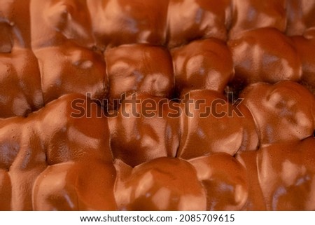 The texture of chocolate profiteroles. Close-up of a profiterole. chocolate coating. Traditional italian dessert profiteroles with chocolate cream
