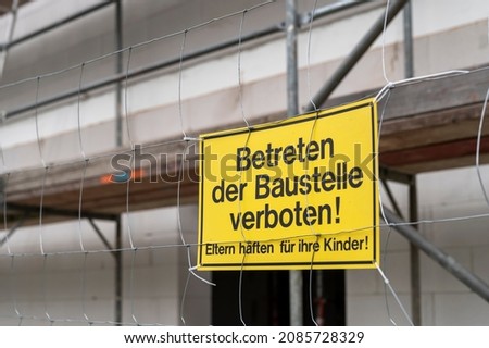 A sign on the construction fence with the German inscription , Entering the construction site prohibited, parents are liable for their children