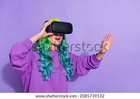 Photo of amazed youth lady with bright hairdo wear goggles search vision cyberspace isolated over purple color background