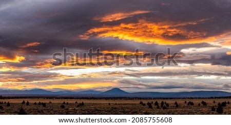 A sunset in the desert in Central Oregon with the Cascade Mountains in the background.
