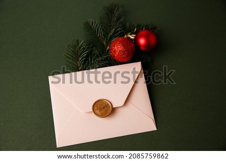 
Beige Christmas envelope on a green background. Congratulatory envelope, invitation.