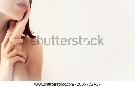 A young girl touches her delicate, clean, moisturized face skin with her hands, a woman takes care of the health and beauty of her body in the bathroom. Royalty-Free Stock Photo #2085772417