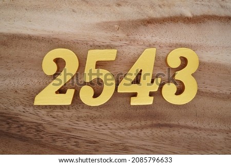 Golden Arabic numerals 2543 on a dark brown to white wood grain background.