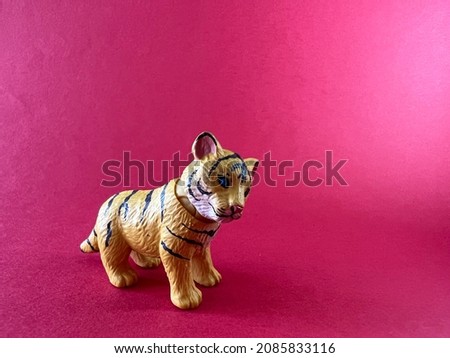Chinese Zodiac Sign Year of Tiger, Happy Chinese New Year, Year of the Tiger. A miniature of a tiger on a red background.