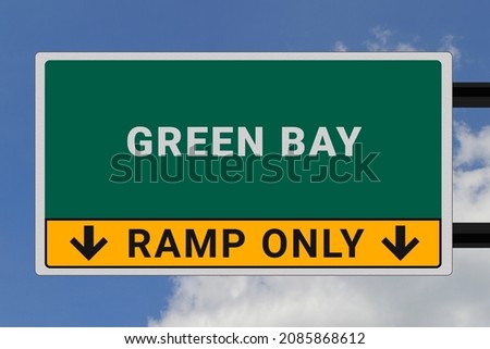Green Bay logo. Green Bay lettering on a road sign. Signpost at entrance to Green Bay, USA. Green pointer in American style. Road sign in the United States of America. Sky in background