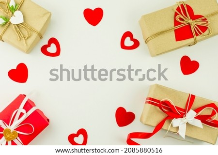 Valentine's Day holiday background. gift boxes in craft paper, decorated with colored hearts and red hearts on a white background. top view. flat lay.