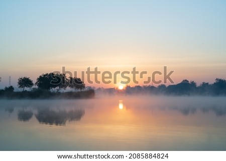 Morning time on the lake and mist fog.The trees and foggy with sun rise sky and reflective in the water.Natural landscape in the morning time. Royalty-Free Stock Photo #2085884824