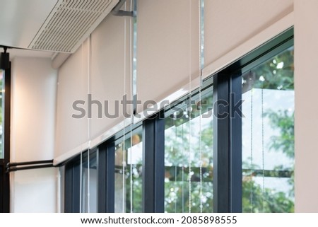 white curtain or white blinds Roller sun protection in office with garden view background. Royalty-Free Stock Photo #2085898555