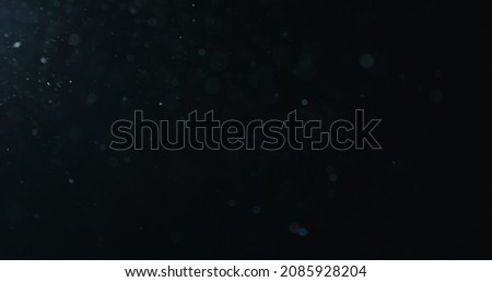 natural dust particles flow in air on black background Royalty-Free Stock Photo #2085928204