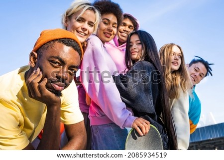 Multicultural group of young friends bonding outdoors and having fun - Stylish cool teens gathering at urban skate park Royalty-Free Stock Photo #2085934519