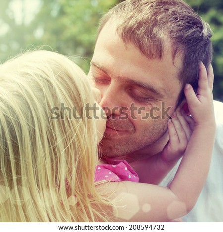 Little girl kissing her father
