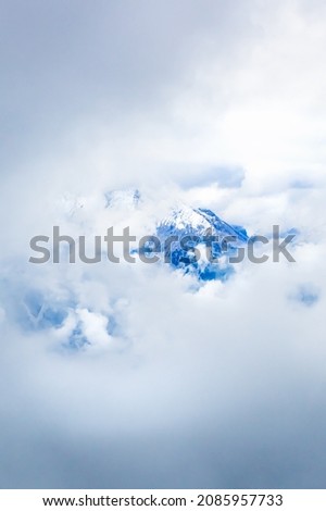 The top of a mountain appears through the thick clouds in the high mountains.