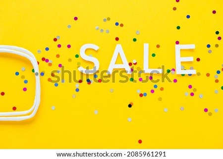 Sale with colorful confetti on yellow background