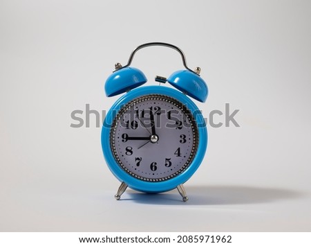 Alarm clock over white. Time concept. Blue alarm clock morning time. Blue alarm clock with copy space.
Blue alarm clock with copy space on a white background.